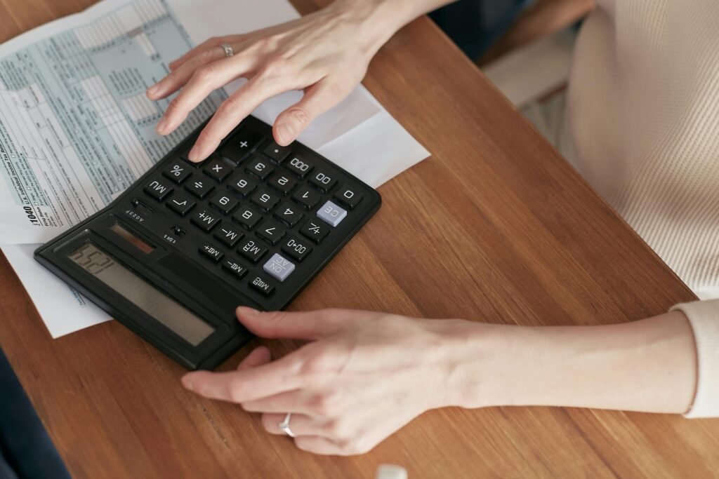 Mulher fazendo contas após aplicar 7 Dicas de Finanças Pessoais que a ajudaram a organizar a vida dela em 2025